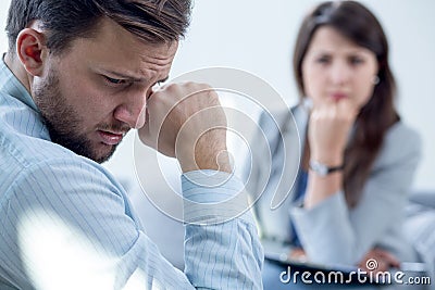 Resigned man at psychiatrist's office Stock Photo