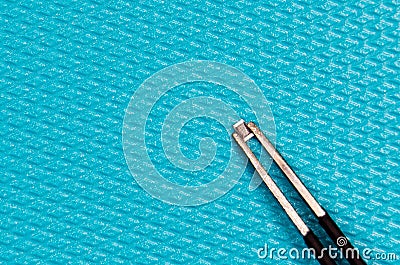 220? resistor and tweezers on a blue background Stock Photo