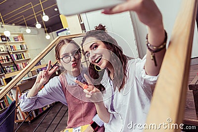 Resolute cheerful girlfriends being unnatural on joint photo Stock Photo