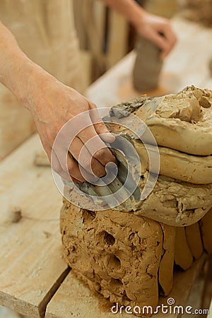 Resolute clay master taking extra materials from a pile Stock Photo