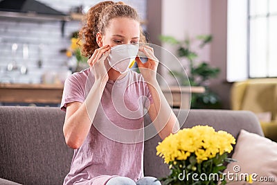 Resolute long-haired woman wearing special mask while suffering Stock Photo