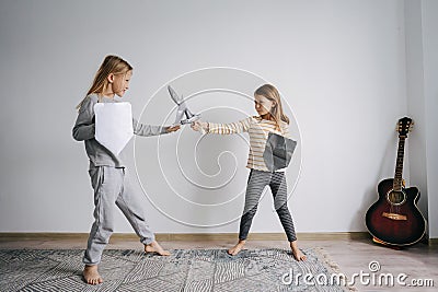 Resolved siblings battling with self-made toy paper swords and shields Stock Photo