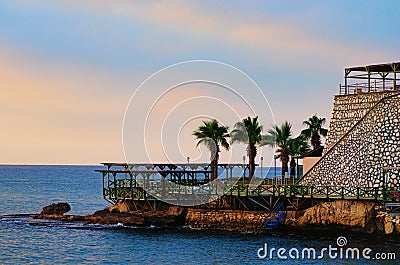 Resort area near hotel in Turkey. Scenic morning landscape view of embankment with empty chaise lounges and palm trees. Stock Photo