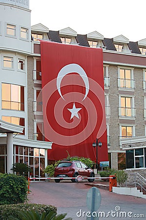 Resort of Kemer, Turkey. The big Turkish state flag is deployed on the building of the hotel Editorial Stock Photo