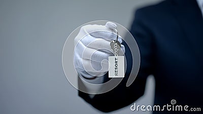 Resort word on keychain in receptionist hand, luxury housing rentals on vacation Stock Photo