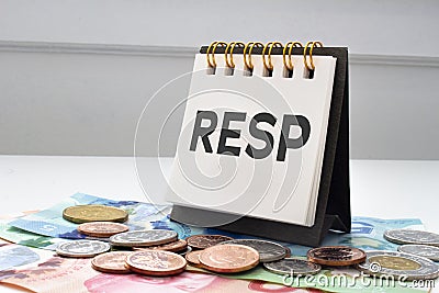 RESP letters on notebook with coins and bills on a clear background Stock Photo