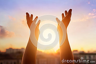 Respect and pray on the sunset in city background Stock Photo