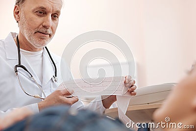 Responsible clever cardiologist explaining the results to his patient Stock Photo