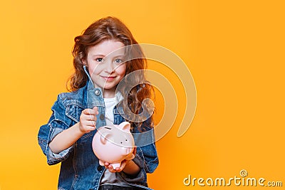 Responsible girl putting money into piggy bank for future saving Stock Photo