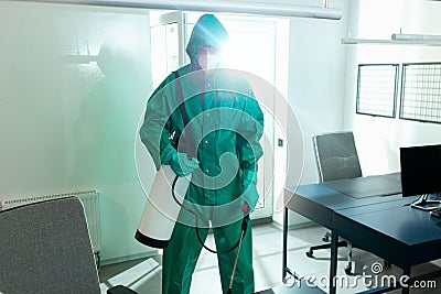 Responsible specialist sanitizing the office during COVID-19 pandemic Stock Photo