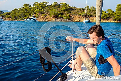 Rest on the sea, boat trip on a yacht. A young man in blue t-shirt. Stock Photo