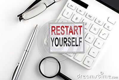 RESTART YOURSELF text on the sticker with calculator, glasses and magnifier Stock Photo