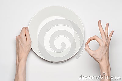 Restaurant and Food theme: the human hand show gesture on an empty white plate on a white background in studio isolated top view Stock Photo