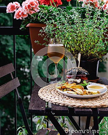 Restaurant table on terrace with hamburger, roasted potatoes and beer Stock Photo