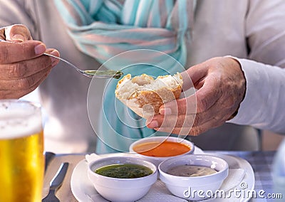 At the restaurant table a woman tastes one of the.typical sauces of the Canary Islands, called Stock Photo