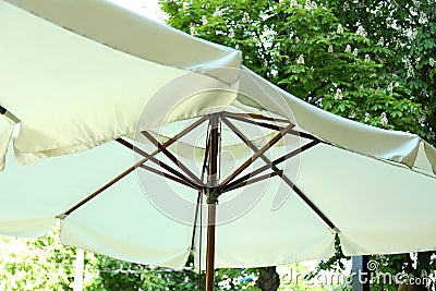 Restaurant umbrellas outdoor against green trees in sunny day Stock Photo