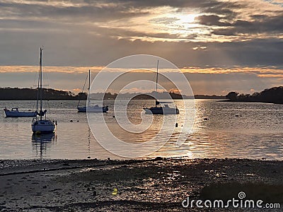 Resting boats at dusk with sunrays Stock Photo