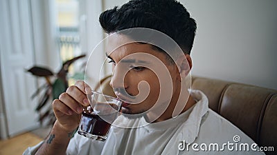 Resting man drinking whiskey glass at home portrait. Calm guy tasting alcohol Stock Photo