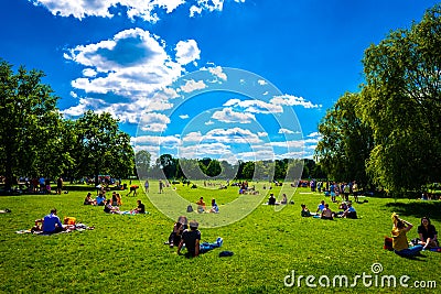 People in a park on a sunny day in Clapham, London Editorial Stock Photo