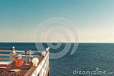 Resting by the sea. Table and chairs on a wooden balcony with a Stock Photo