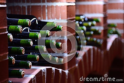 Resting wine bottles stacked in a stone brick vault Stock Photo