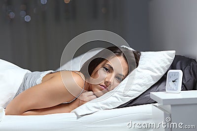 Restless girl suffering insomnia looking at you Stock Photo