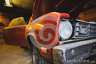 Restoration of scratched classic car. Close up view front side classic car, front headlight of a broken dusty car during Stock Photo