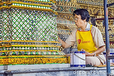 Restorer working on a mosaique in Bangkok's Grand Palace Editorial Stock Photo