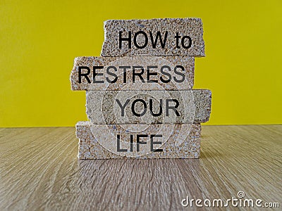 Restress your life symbol. Concept words How to restress your life on brick blocks. Beautiful wooden table yellow background. Stock Photo