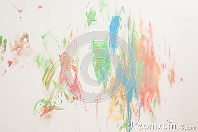 Unguarded small lady painted a clear white home wall with several colors Stock Photo