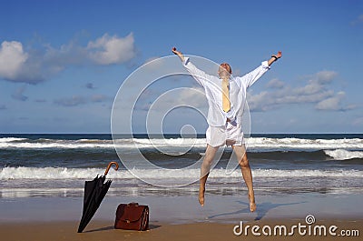 Retired businessman jumping with happiness on a beautiful tropical beach, retirement freedom concept Stock Photo