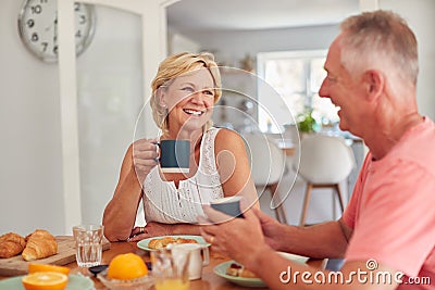 Retired Couple At Home In Kitchen Eating Breakfast Together Stock Photo