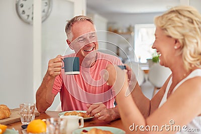 Retired Couple At Home In Kitchen Eating Breakfast Together Stock Photo