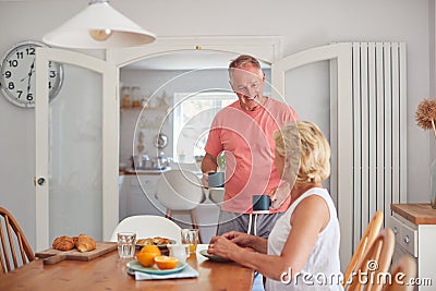 Retired Couple At Home In Kitchen Eating Breakfast Together Stock Photo