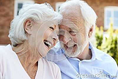 Retired Couple Sitting On Bench And Talking In Assisted Living Facility Stock Photo