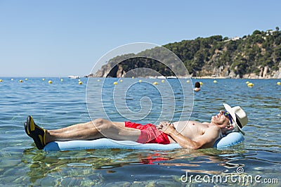 Retired man sleeping on bed in sea water Stock Photo