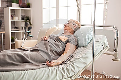 Retired old woman sleeping on bed Stock Photo