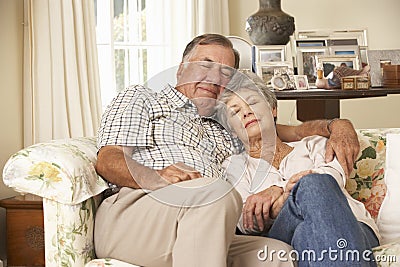 Retired Senior Couple Dozing On Sofa At Home Together Stock Photo