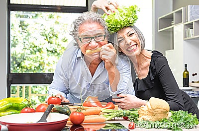 Retired senior couple having fun in kitchen with healthy food Stock Photo