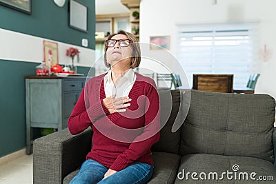 Retired Woman With Chest Pain At Home Stock Photo