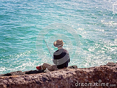 Retiree Male Fishing From Breakwater Rocks Editorial Stock Photo