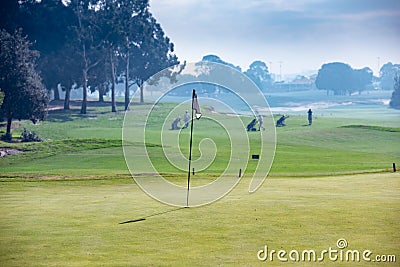 Retiree men approaching putting green on golf course. Editorial Stock Photo