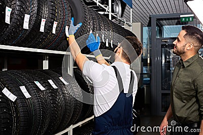 retirement man touching and choosing for buying a tire, measuring rubber car wheel Stock Photo