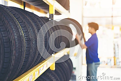 Retirement man touching and choosing for buying a tire in a supermarket mall. Measuring rubber car wheel Stock Photo
