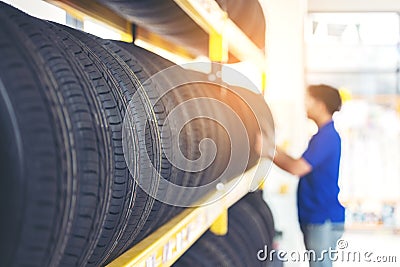 Retirement man touching and choosing for buying a tire in a supermarket mall. Measuring rubber car wheel Stock Photo