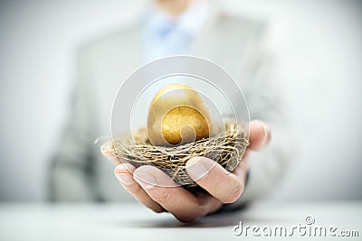 Retirement savings golden nest egg in businessman hand Stock Photo