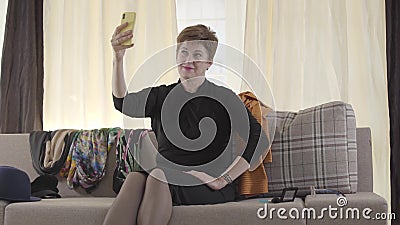 Retrato da bela dama caucasiana gravando vídeo selfie em seu smartphone Mulher-blogueira madura acenando vídeos de arquivo Retrato da bela dama caucasiana gravando vídeo selfie em seu smartphone Mulher-blogueira madura acenando vídeos de arquivo