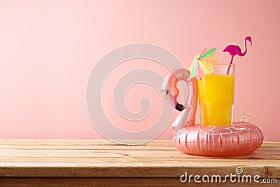 Retro aesthetic 80s concept with orange juice and flamingo pool float. Summer vacation vibes background Stock Photo