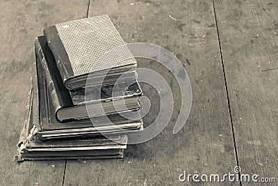 Retro aged books on oak wooden table. Vintage style sepia photo Stock Photo