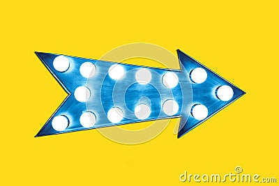 Retro blue arrow shaped vintage colorful illuminated metallic display sign with glowing light bulbs Stock Photo